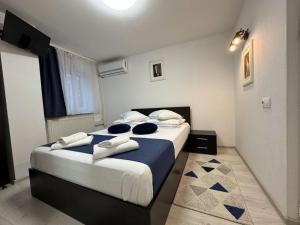 a bedroom with a large bed with blue pillows at Pensiunea Pictorilor in Baia Mare