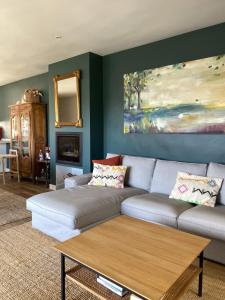 ein Wohnzimmer mit Sofa und Tisch in der Unterkunft La Casa de la Sierra de Madrid in Hoyo de Manzanares