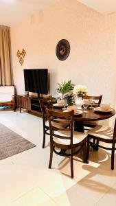 a dining room with a table with chairs and a television at Al Reem 1BR City View Pool Gym Family Biz Friendly Abu Dhabi in Mushayrib
