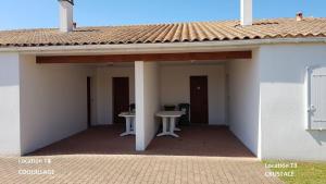 a porch of a house with a table and a roof at Superbe Logement à 200 m de la Plage ! T4 Coquillages in Saint-Pierre-dʼOléron +15 photos