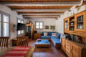 a living room with a blue couch and a table at Sandy Beachfront House Ganema Serifos in Ganema