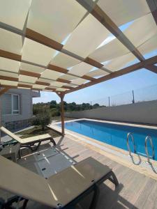 a patio with a canopy over a swimming pool at Detached villa in antkoop in Serik