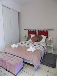 a bedroom with a large bed with two ottomans at Studio Revy 3 - Coeur de Ville in Néris-les-Bains