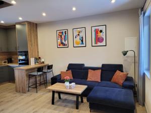 a living room with a blue couch and a table at Apartament Vici nad jeziorem Nyskim in Skorochów