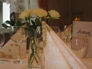 una mesa con copas de vino y flores. en Hotel Lindenhof en Meschede