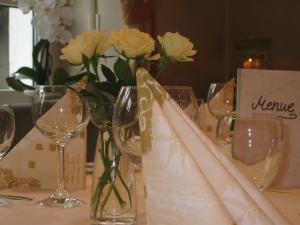 una mesa con copas de vino y flores. en Hotel Lindenhof, en Meschede