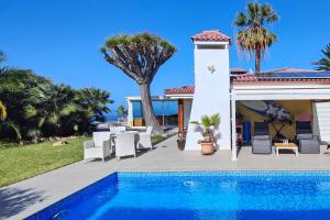 a villa with a swimming pool and palm trees at Casita Salpino in Sauzal