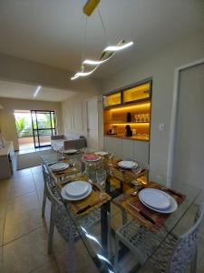 ein Esszimmer mit Glastisch und Stühlen in der Unterkunft Flat Aquaville perto do Beachpark com 3 Suites in Aquiraz