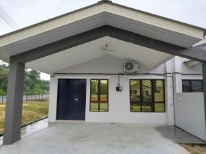 a white house with a garage with a door at Golden Paradise Fully Aircond in Kuantan