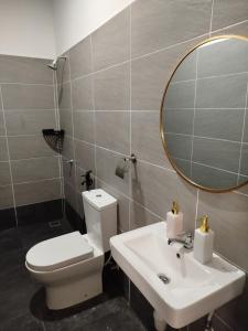a bathroom with a toilet and a sink and a mirror at Golden Paradise Fully Aircond in Kuantan +13 photos