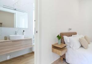 un bagno bianco con lavandino e specchio di Dolce Vita Guest House a Torre del Greco