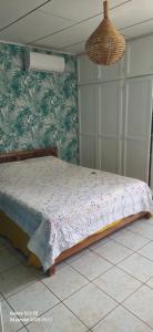 a bedroom with a bed with a floral wall at Ty kaz les bains in Saint-Paul