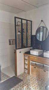 a bathroom with a counter with a sink and a mirror at Ty kaz les bains in Saint-Paul