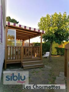 a wooden gazebo with a bench in a yard at Mobil Home tout confort 6 a 8 personnes Aux Charmettes in Les Mathes