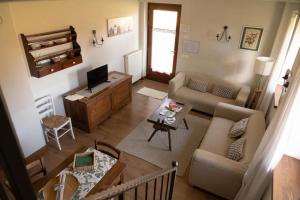 a living room with a couch and a tv at Fienile Chiaramada in Belluno