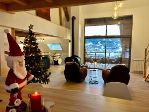 a christmas tree in a living room with a candle at Loft Ô Faix in Ancelle