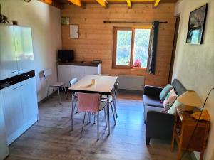 Una sala de estar con una mesa y una cocina. en Les quatre marmottes, en Villar-dʼArène