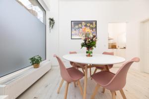 a dining room with a white table and pink chairs at Great 2-room apartment in Mitte in Berlin +20 photos