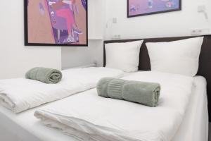 two white beds with towels on them in a room at Great 2-room apartment in Mitte in Berlin