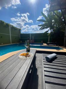 a plate of pizza and a glass of wine on a table by a pool at Rincón del parana in Puerto Iguazú