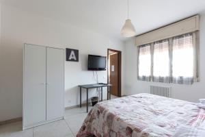 een slaapkamer met een bed en een tv aan de muur bij FARE BnB - Room Pappagnocca in Reggio Emilia
