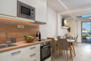 une cuisine avec un évier et une table avec des chaises dans l'établissement Lente vivus suites, à Marathias 4 autres photos