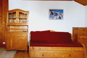 a bedroom with a bed and a wooden cabinet at Le Chalet de Poche - Gite 2 étoiles - 5 pers in Habère-Poche