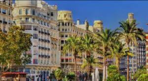a large building with palm trees in front of it at Amplio Estudio en Valencia in Valencia