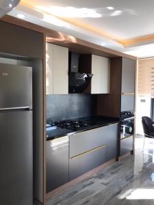 a kitchen with a stove and a refrigerator at Detached and luxury villa in kadriye in Belek
