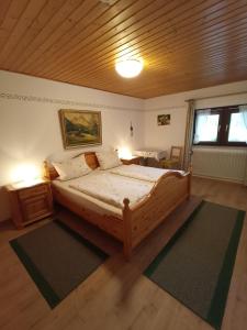 a bedroom with a large bed with a wooden ceiling at Landhaus Kamml in Anger