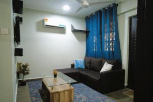 a living room with a couch and a table at The Plan Budget Apartment Borteyman Accra in Accra