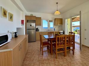 a kitchen and dining room with a table and chairs at Villa Dimitra in Trapezaki
