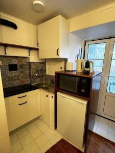 リスボンにあるCantinho das Portas do Sol IIの白いキャビネットと電子レンジを備えたキッチン +27枚の写真