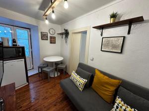 a living room with a gray couch and a kitchen at Cantinho das Portas do Sol II in Lisbon