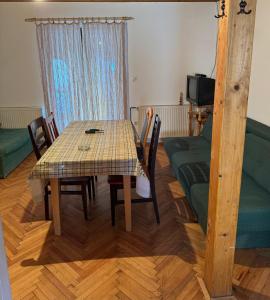 a dining room with a table and chairs and a couch at Apartmani Tara Vila Isidora in Bajina Bašta