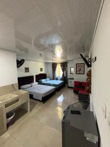 a bedroom with two beds and a desk in it at Habitación la esmeralda in Puerto Triunfo +2 photos