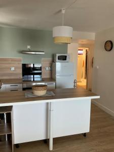 a kitchen with a white island in a room at Appartement cosy avec garage in Le Tampon