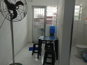 a small room with a table and a fan at Suítes Cristall in São Sebastião +80 photos