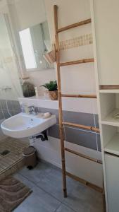 a bathroom with a sink and a ladder next to a toilet at Appartement central avec parking in Carcassone