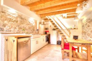 a kitchen with wooden ceilings and a wooden table at La Cabane du Lys in Les Déserts