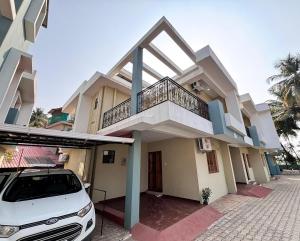 a white car parked in front of a house at Cozy 3 BHK row house near Panjim in Bambolim