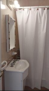 een badkamer met een wastafel en een wit douchegordijn bij Travel ART! in Mar del Plata +17 foto's