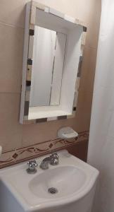 een badkamer met een wastafel en een spiegel bij Travel ART! in Mar del Plata