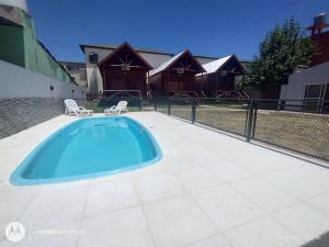 a swimming pool with two chairs and a house at Un rincon de paz in Colón