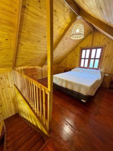 a bedroom in a log cabin with a bed in it at Un rincon de paz in Colón +5 photos