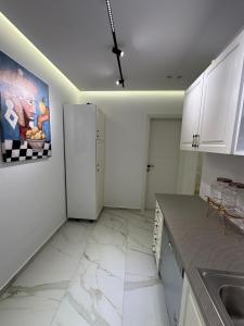 ヴロラにあるIonian Coast Apartmentの白いキャビネットと冷蔵庫のあるキッチン