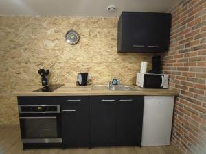a kitchen with a sink and a brick wall at Le Stud'Eure in Saint-André-de-lʼEure +14 photos