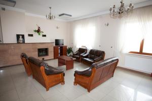 sala de estar con muebles de cuero y chimenea en Ośrodek Wypoczynkowy Sowa, en Lipniak