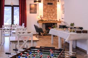 a room with tables and chairs and a fireplace at Karkonoskie Widoki Apartamenty in Karpacz