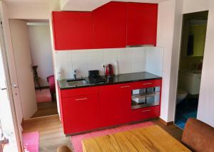 a red and white kitchen with a sink at Pilgerwohnung in Wald